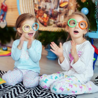 children with glasses in the room sing. Two sisters. The concept of Christmas and New Year.